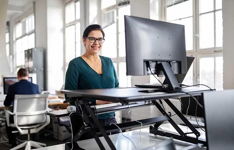 A woman working at a standing desk.