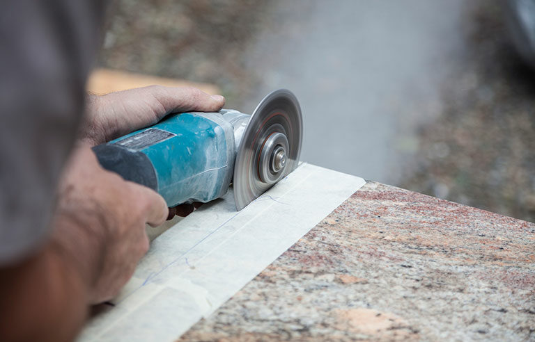 a saw cutting a stone countertop