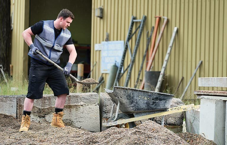 A worker shoveling sand