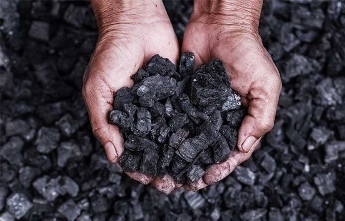 a pair of hands holding coal