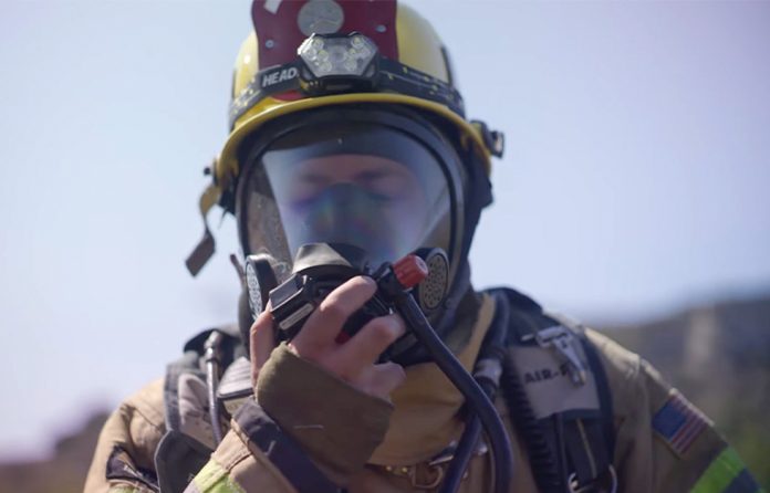 A male firefighter wearing a respirator protection mask